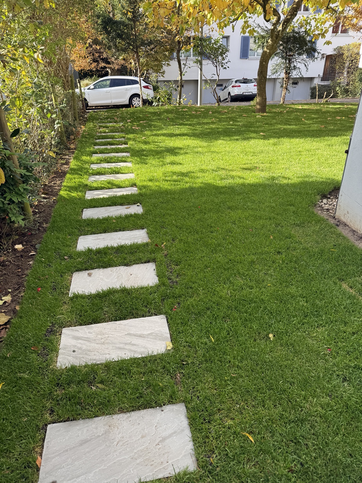 Grüne Rasenfläche mit Trittplatten in einem Garten